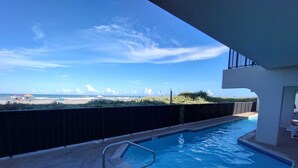 Una piscina con vista a la playa y al océano.