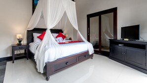 A bedroom with a four-poster bed, a nightstand, a TV, and a wardrobe.