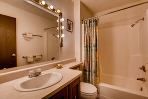 Une salle de bain équipée d’un lavabo, d’un miroir et d’un rideau de douche.