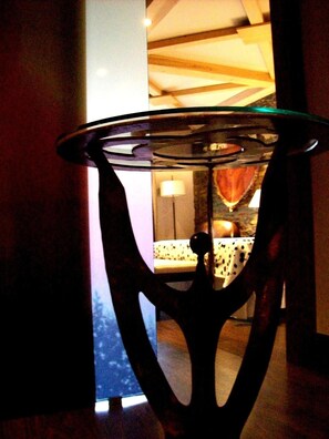 Uma mesa com tampo de vidro e design exclusivo na base de metal.