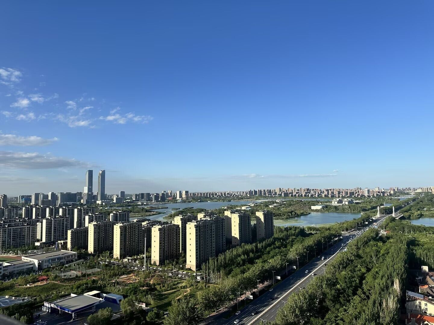A cityscape with high-rise buildings, a river, and a bridge.