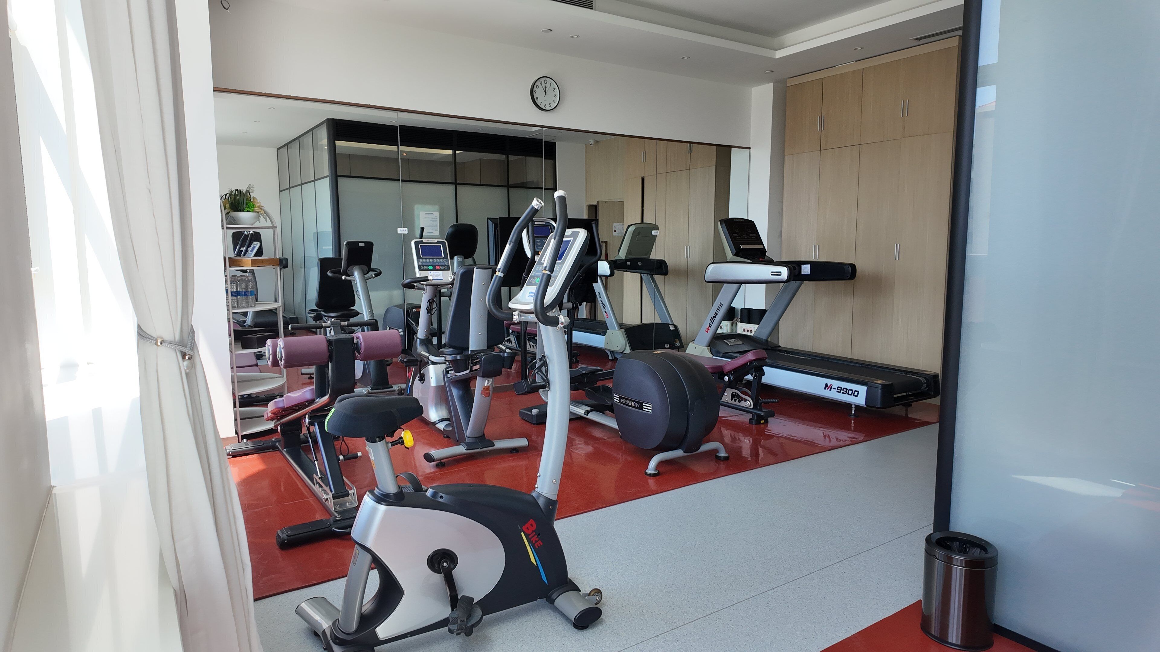 A gym with cardio machines, weight equipment, and a treadmill.