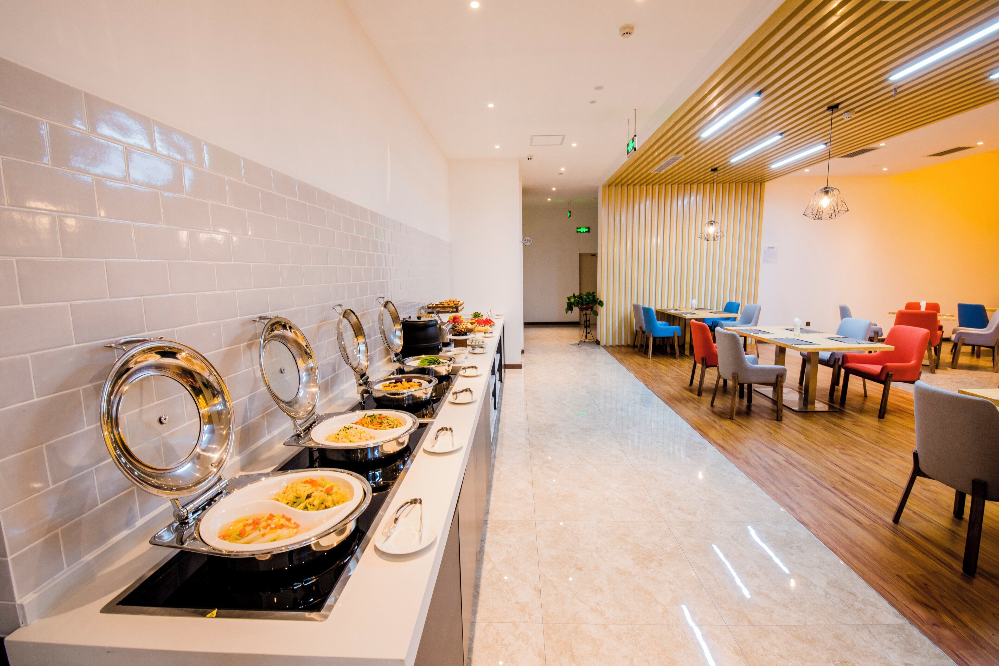 Ein reichhaltiges Buffet mit verschiedenen Servicestationen und einer Sitzgelegenheit mit Tischen und Stühlen.
