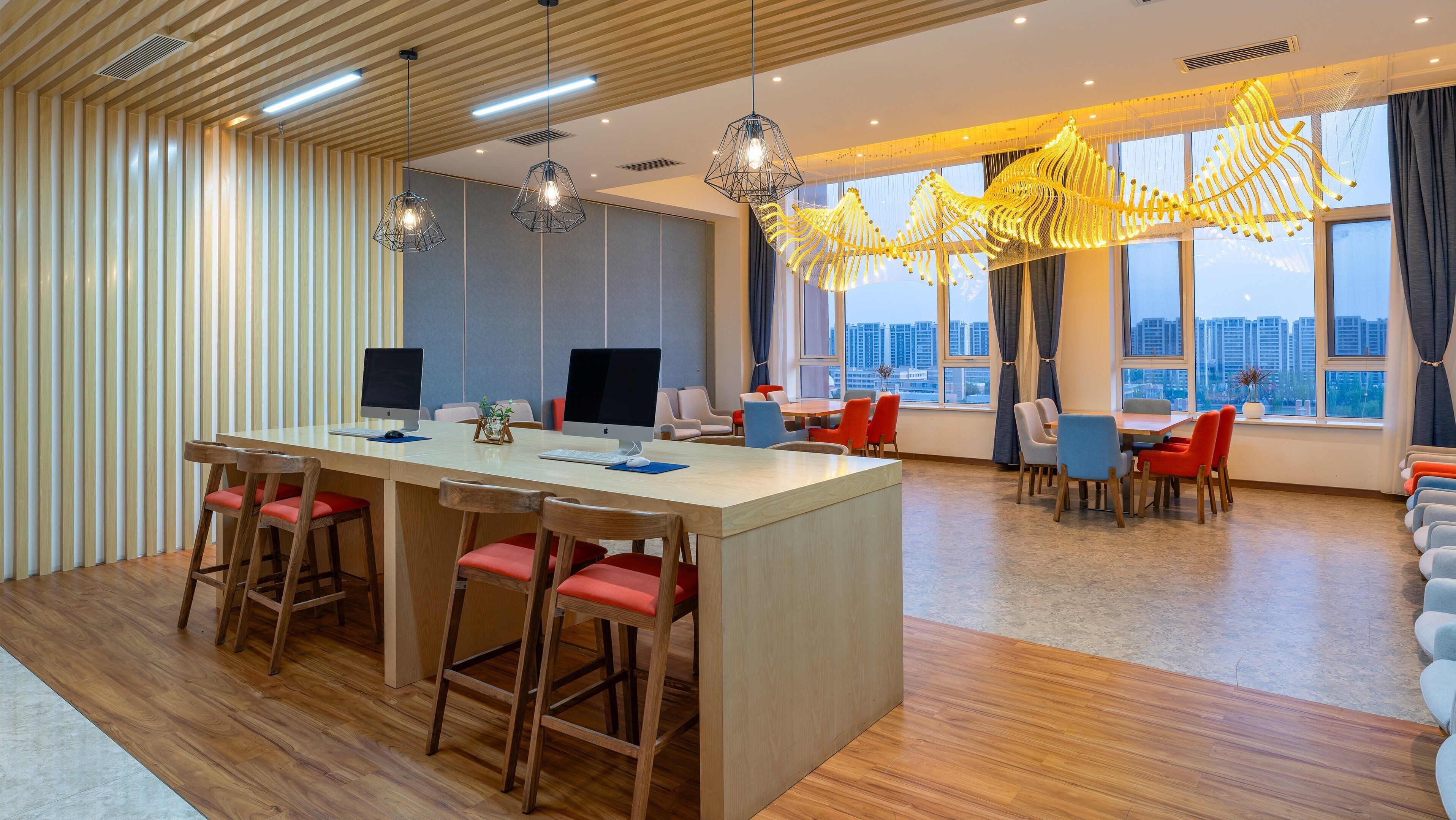 A modern hotel lobby with a central island, bar stools, and a dining area with chairs and tables.