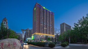 A tall hotel with multiple floors and a prominent sign on top. - Holiday Inn Express Yinchuan Downtown by IHG (Yinchuan)