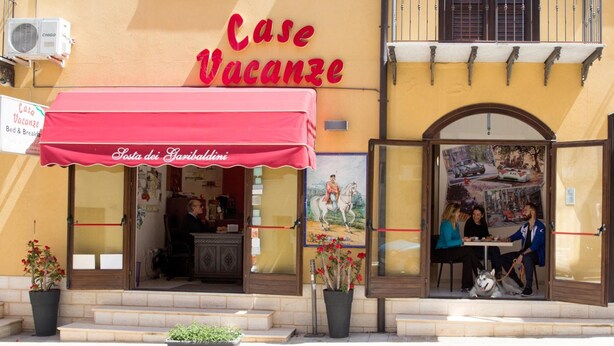 A building with a red awning labeled "Case Vacanze" and a sign "Sosta dei Garibaldi". - Sosta dei Garibaldini (Campofelice di Roccella)