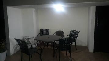 A small, enclosed dining area with a round table and four chairs.