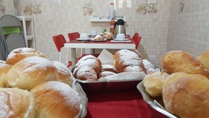 A dining table with various pastries and a coffee maker. - Edelweiss B&B (Salerno)