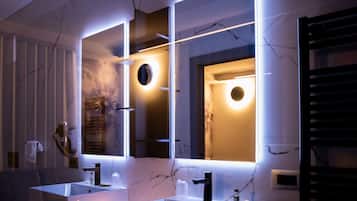 Un baño moderno con dos lavamanos, un espejo e iluminación debajo del gabinete.