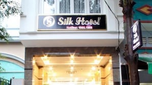 A hotel entrance with a sign reading "Silk Hotel" and a contact number. - Silk Hotel (Ho Chi Minh City)