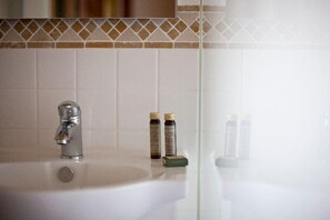 A bathroom sink with a faucet, two bottles of liquid soap, and a bar of soap. - Herdades da Frupor (Odemira)