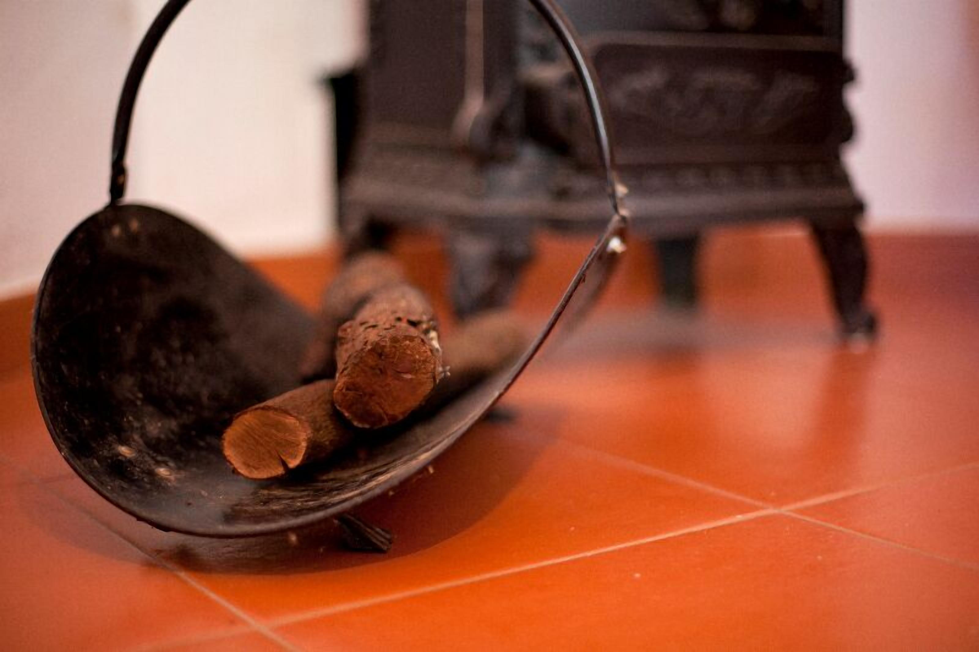 Una cuchara de metal con mango de madera sobre un piso de baldosas.