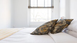 A bedroom with a bed, a window with blinds, and a view of trees outside. - The Marylebone Residence (London)