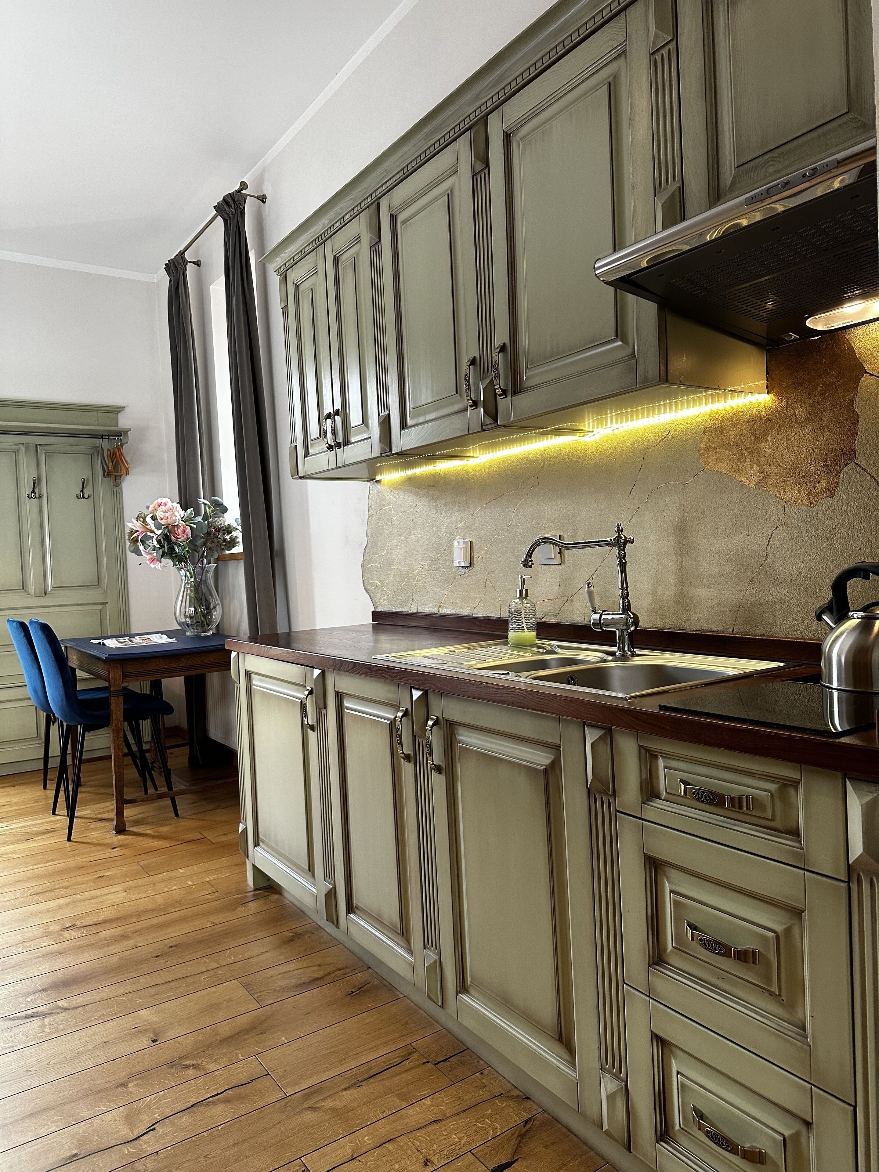 Une cuisine dotée d’un plan de travail en bois, de placards intégrés et d’un évier en acier inoxydable.