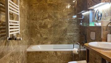 A modern bathroom with a bathtub, toilet, and sink.