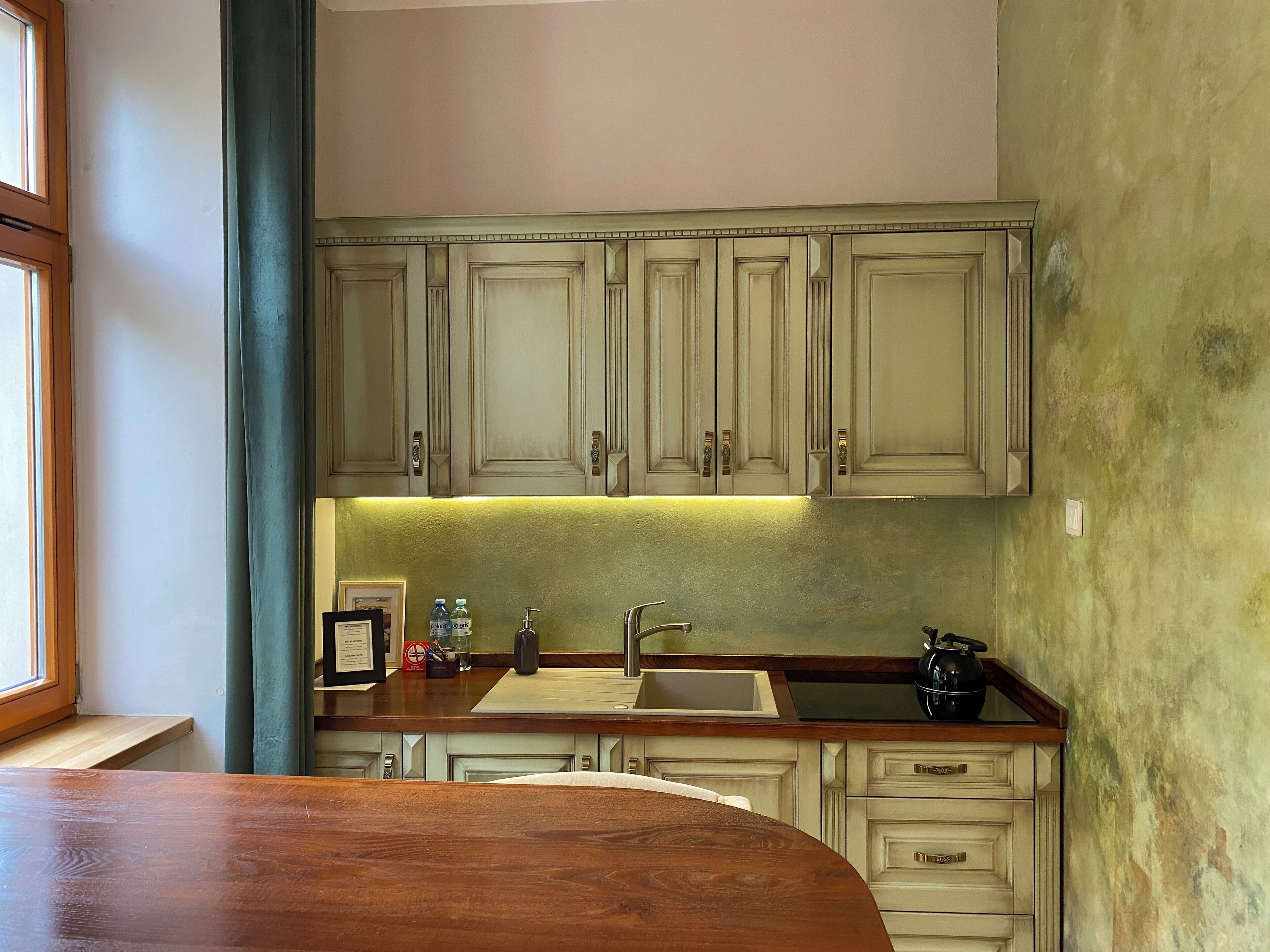 A kitchen with wooden cabinets, a sink, and a countertop.