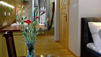 A dining table with a vase of flowers and two wine glasses.