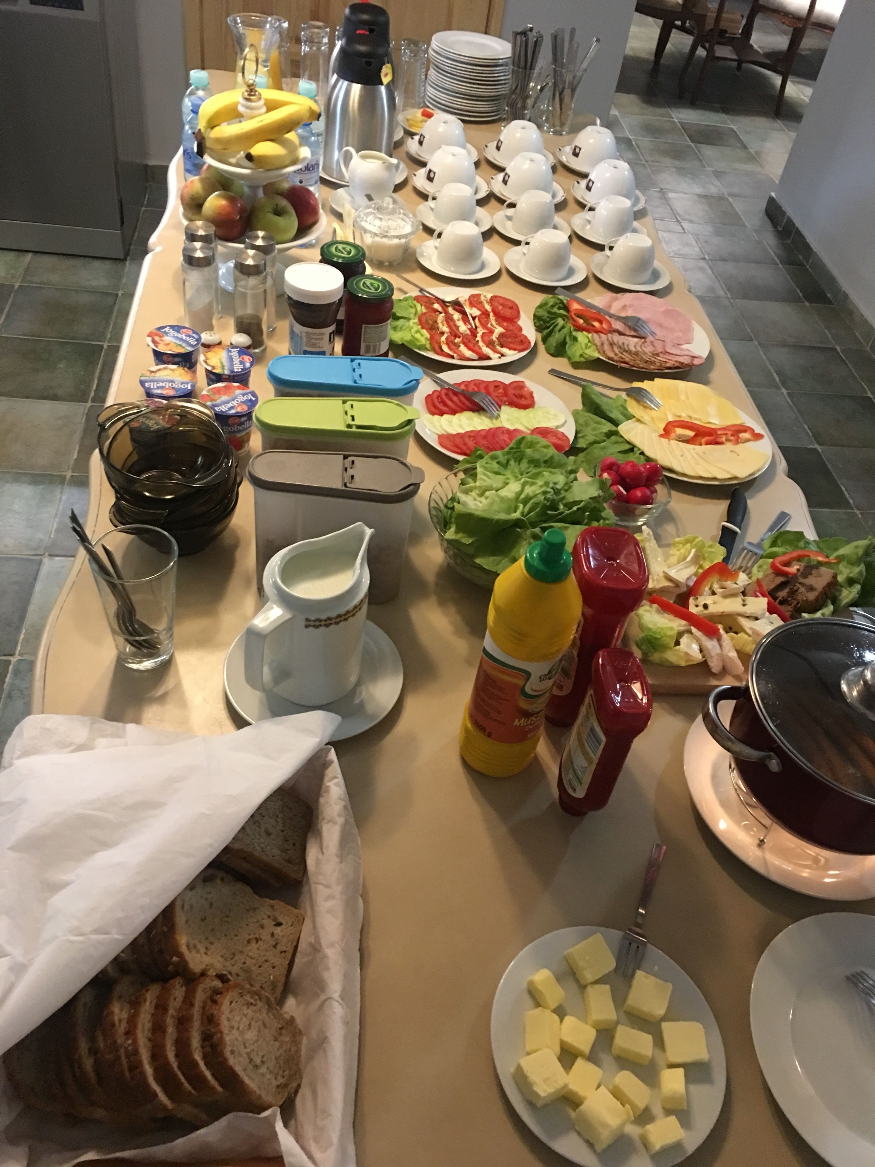 Una mesa de buffet con diversos alimentos, como frutas, verduras, queso y salsas.