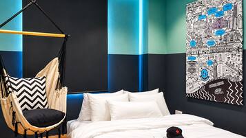 Ein modernes Schlafzimmer mit Hängesessel, einem Bett mit weißer Bettwäsche und Stadtbild-Wandkunst.