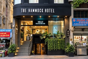 The Hammock Hotel with a modern facade, a staircase leading to the entrance, and a sign that reads 'Hello from the other side'.
