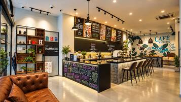 A modern café interior with a bar area, seating, and a visible menu board.