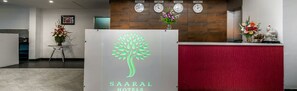 A reception area with a modern design, featuring a reception desk, a clock, and a wall-mounted clock. - Saaral Residency (Chennai)