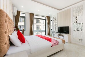 Habitación de hotel moderna con una cama grande, un televisor de pantalla plana y vistas a la ciudad.
