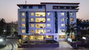 A multi-story hotel with a central atrium, multiple balconies, and a ground-level entrance. - Hotel Sreepathy Indraprastha (Chavakkad)