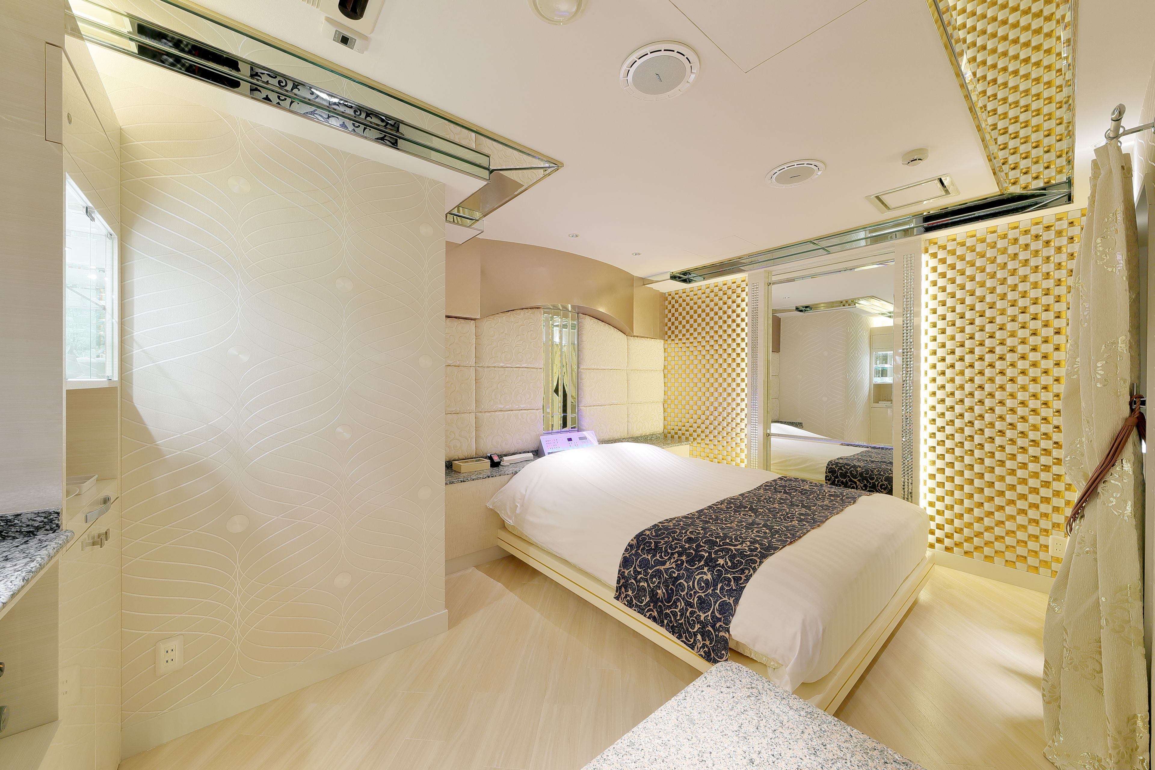 Een moderne slaapkamer met een groot bed, een nachtkastje en een spiegel.