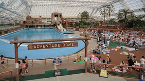 An indoor water park with a large pool, slides, and a sandy play area. - Hotel Cherena - Adult Only (Kunitachi)