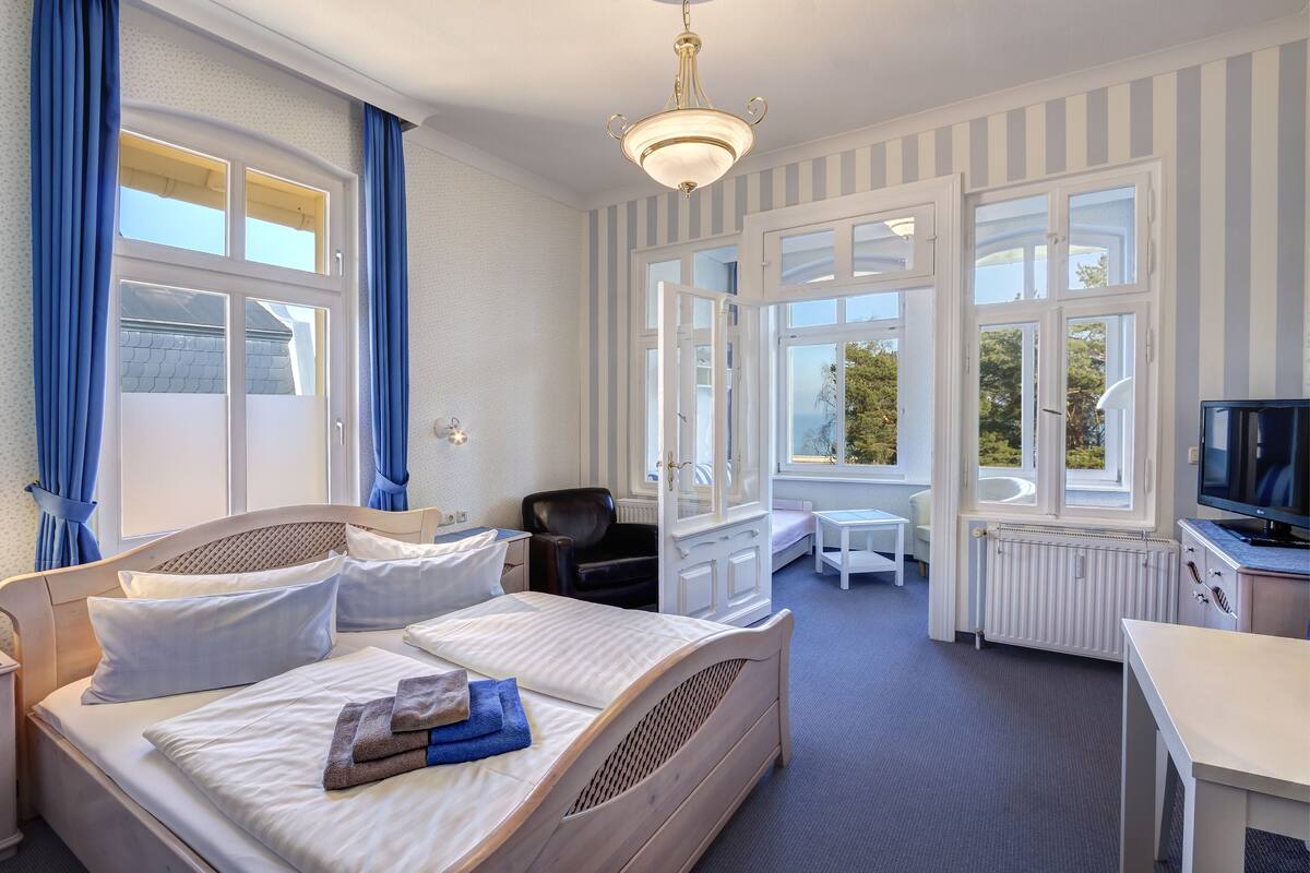 Una habitación de hotel con cama, escritorio, silla y televisor.