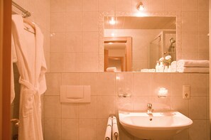 Un bagno con lavandino, specchio e portasciugamani.
