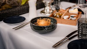 A dining table set with a candle, glassware, and a bowl of noodles. - Parkhotel Herne (Herne)