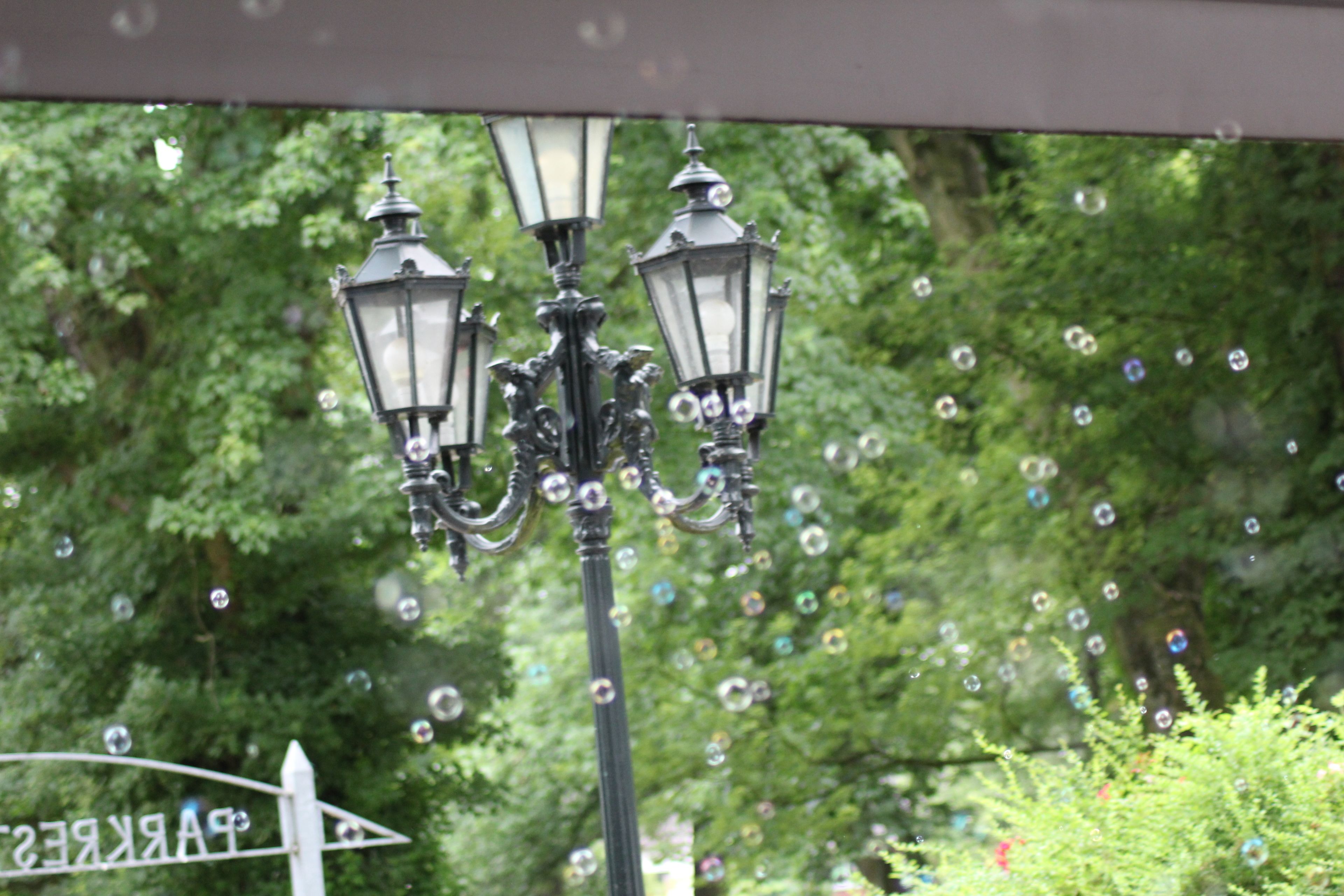 A street lamp with multiple lights and bubbles in the air.