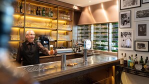 A bar area with shelves of liquor bottles, a beer tap, and a bar counter. - Parkhotel Herne (Herne)