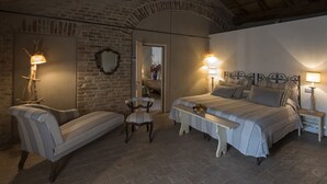 A cozy bedroom with a bed, two bedside tables, a chair, and a lamp. - Antica Corte Pallavicina (Polesine Zibello)