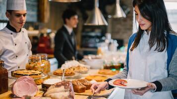 A buffet with various food items and a person serving themselves.
