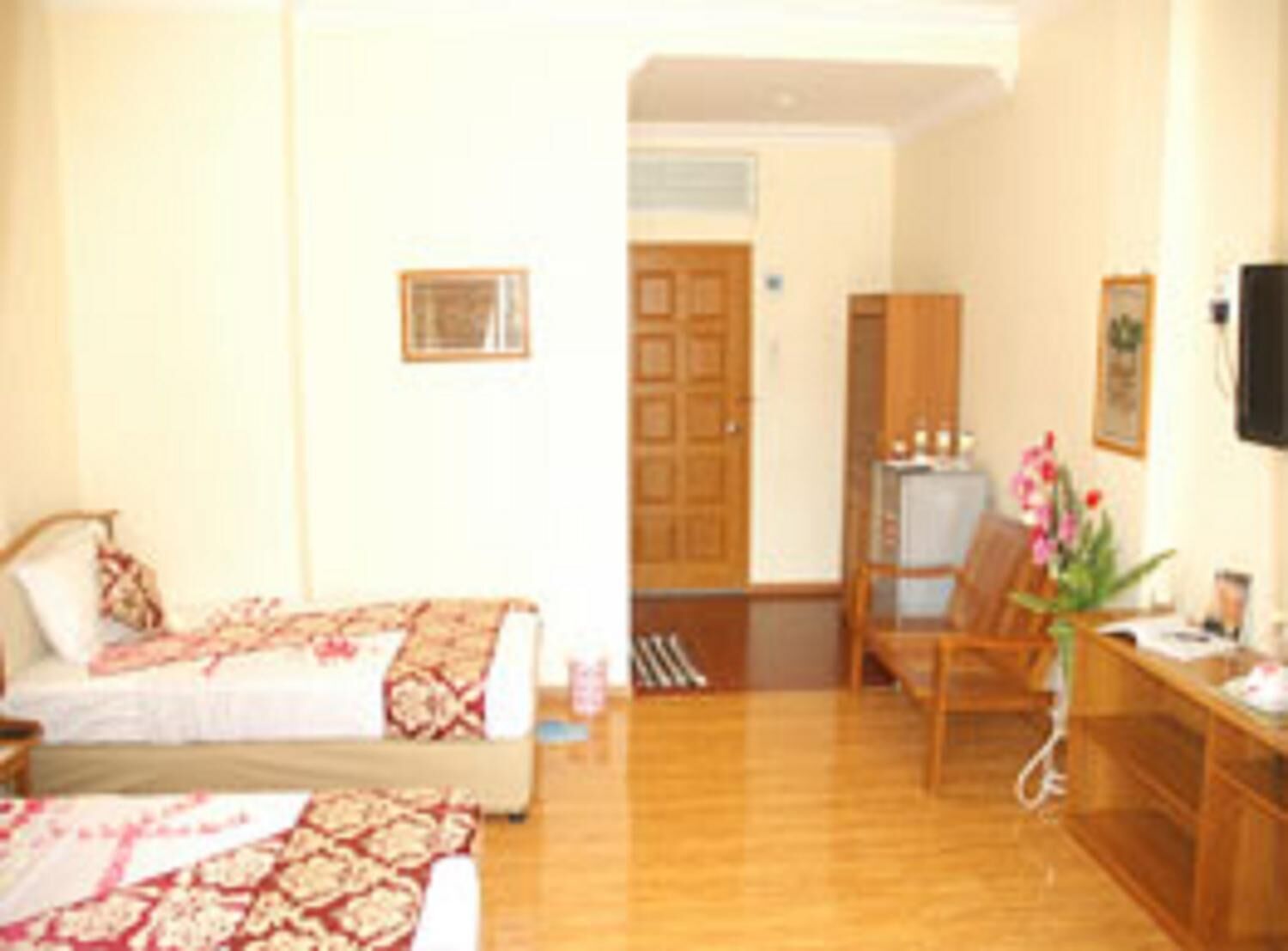 A hotel room with a bed, a desk, a chair, and a television.