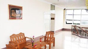 Un comedor con muebles de madera, una mesa con un jarrón de flores y una ventana con vistas.
