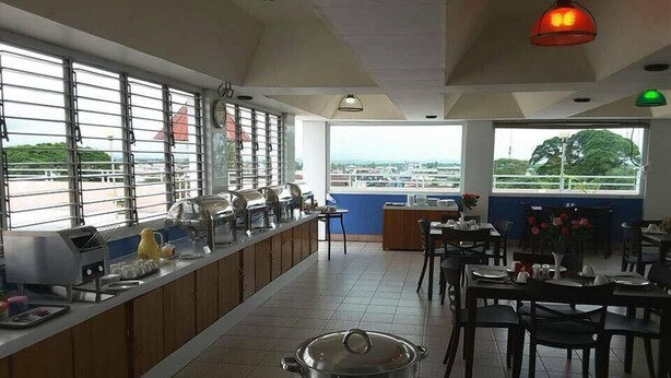 Un restaurante con barra de buffet, un amplio ventanal con vistas y una olla sobre la barra.