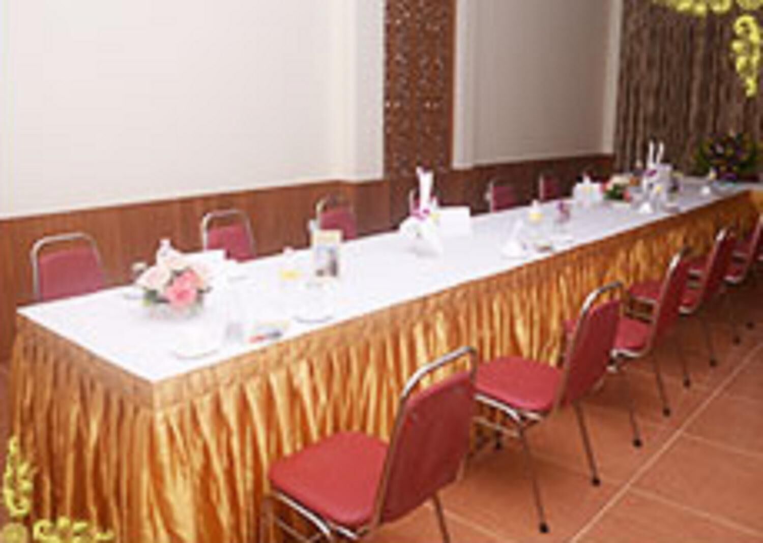 A conference room with a long table, chairs, and a projector screen.