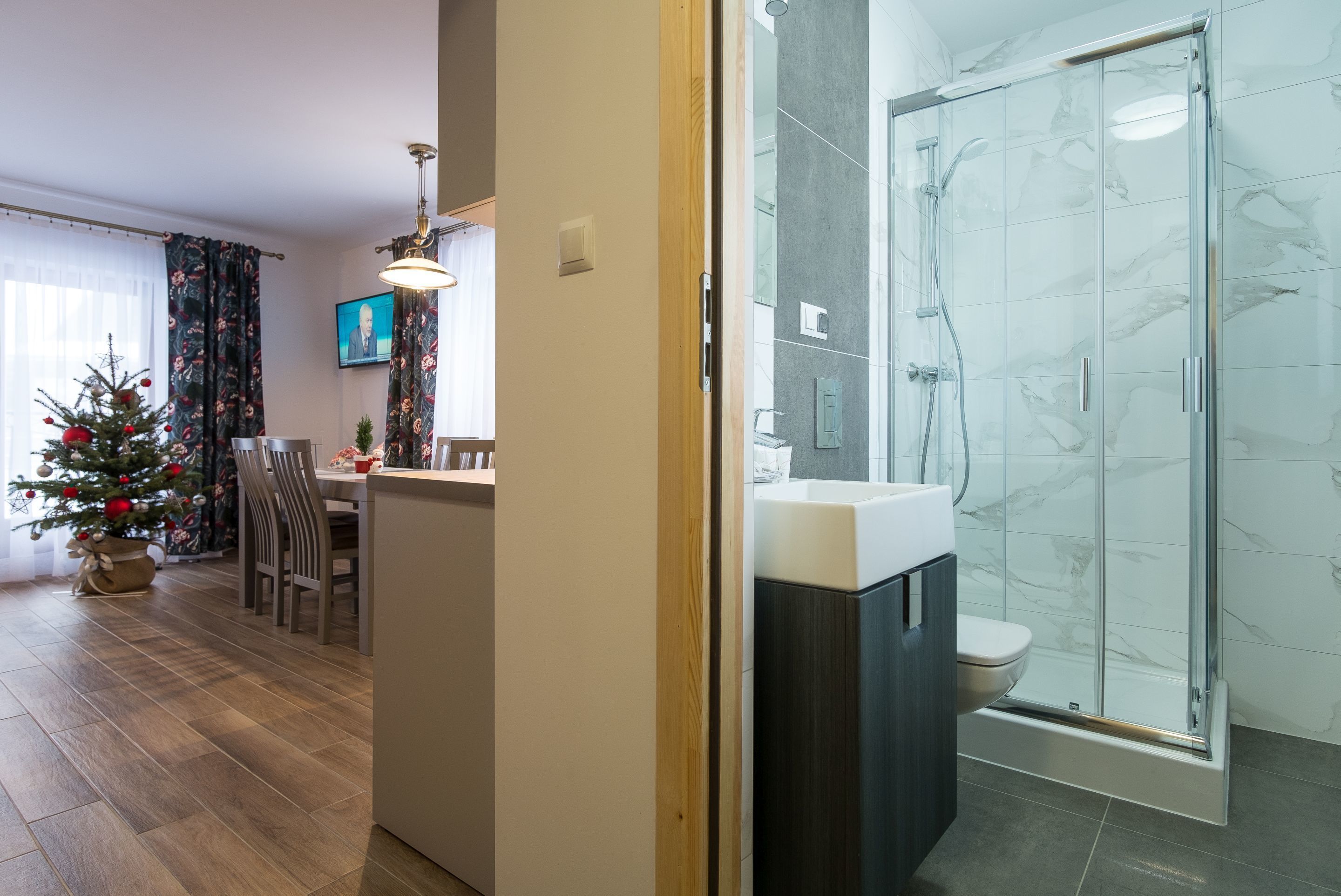 A modern bathroom with a glass shower enclosure and a toilet.