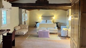 Une pièce confortable avec un lit, deux canapés, une petite table et un meuble.