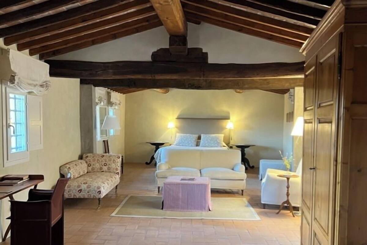 Een gezellige kamer met een bed, twee slaapbanken, een tafeltje en een kast.