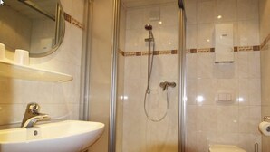 A bathroom with a glass-enclosed shower, a sink, and a toilet. - Weingut Gästehaus Derkum (Uerzig)