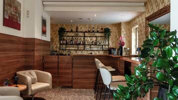 A bar area with a wooden bar counter, multiple stools, and a wall of liquor bottles.