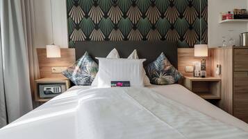 A hotel room with a bed, nightstands, a wooden headboard, and a patterned wallpaper.