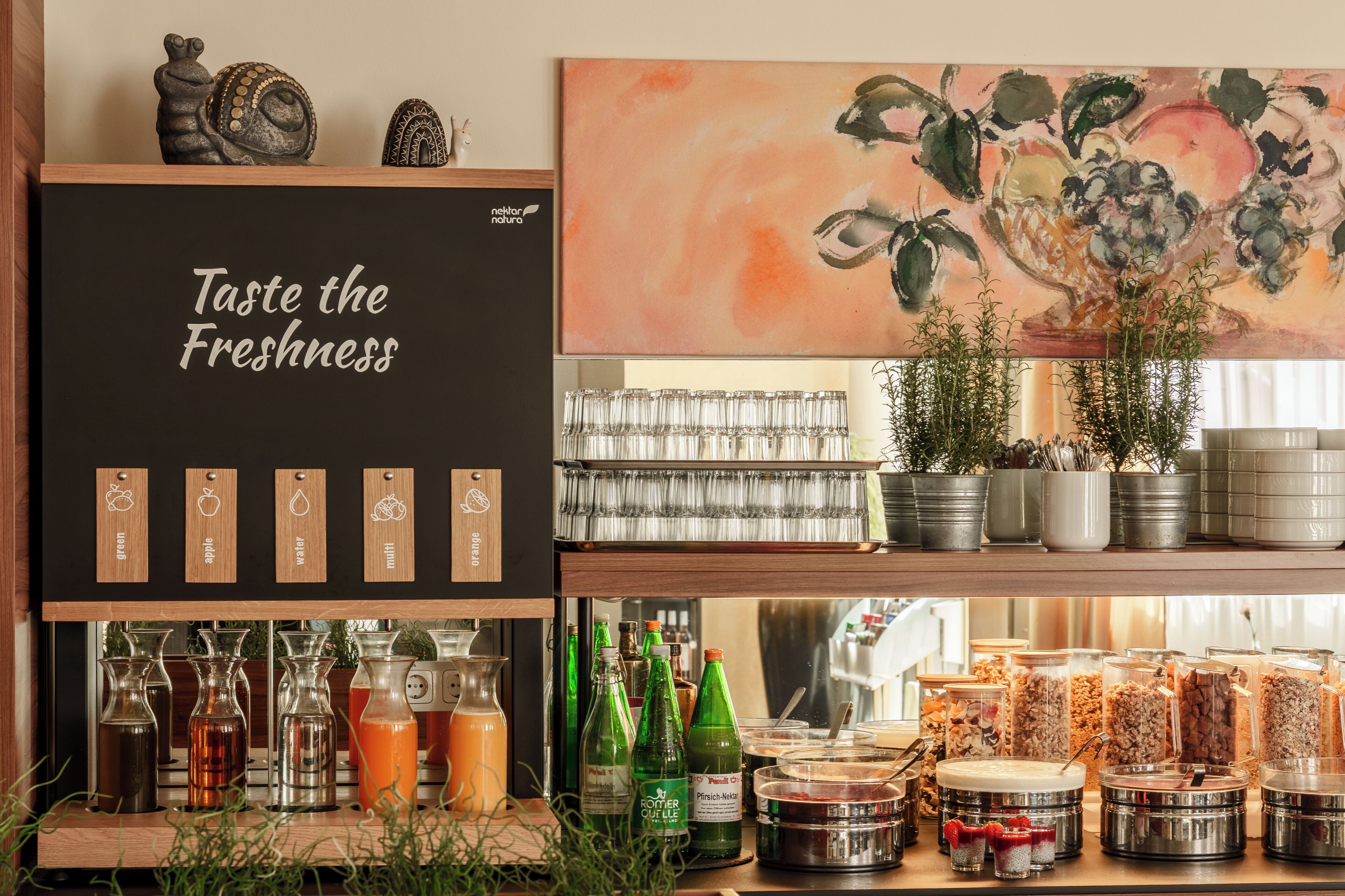 A beverage station with various drink options and a sign that reads 'Taste the Freshness.'