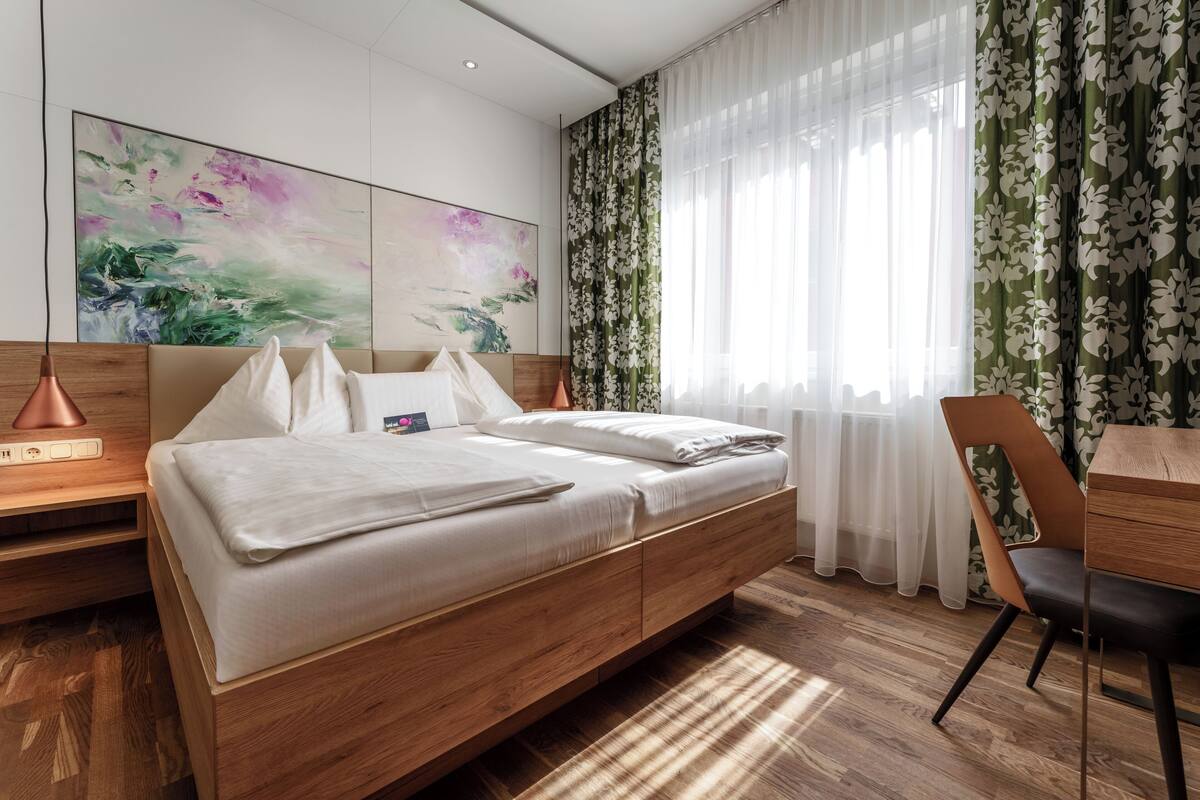 A modern bedroom with a wooden bed, a desk, and a chair.
