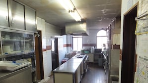 A spacious kitchen with stainless steel appliances, a central island, and a large window providing natural light. - Rental Lodge WHITE RABBIT Madarao kogen Cottage RABBIT (Iiyama)